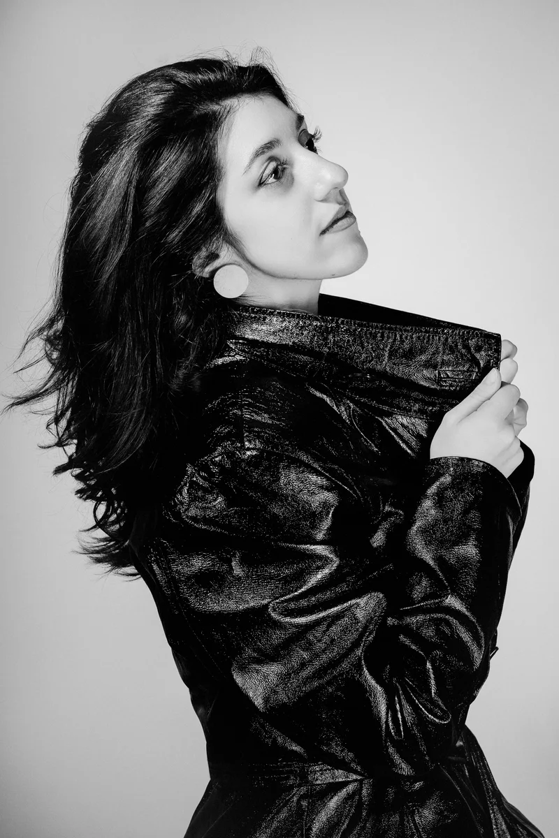 Woman in a leather jacket looking up over her shoulder in a monochrome portrait