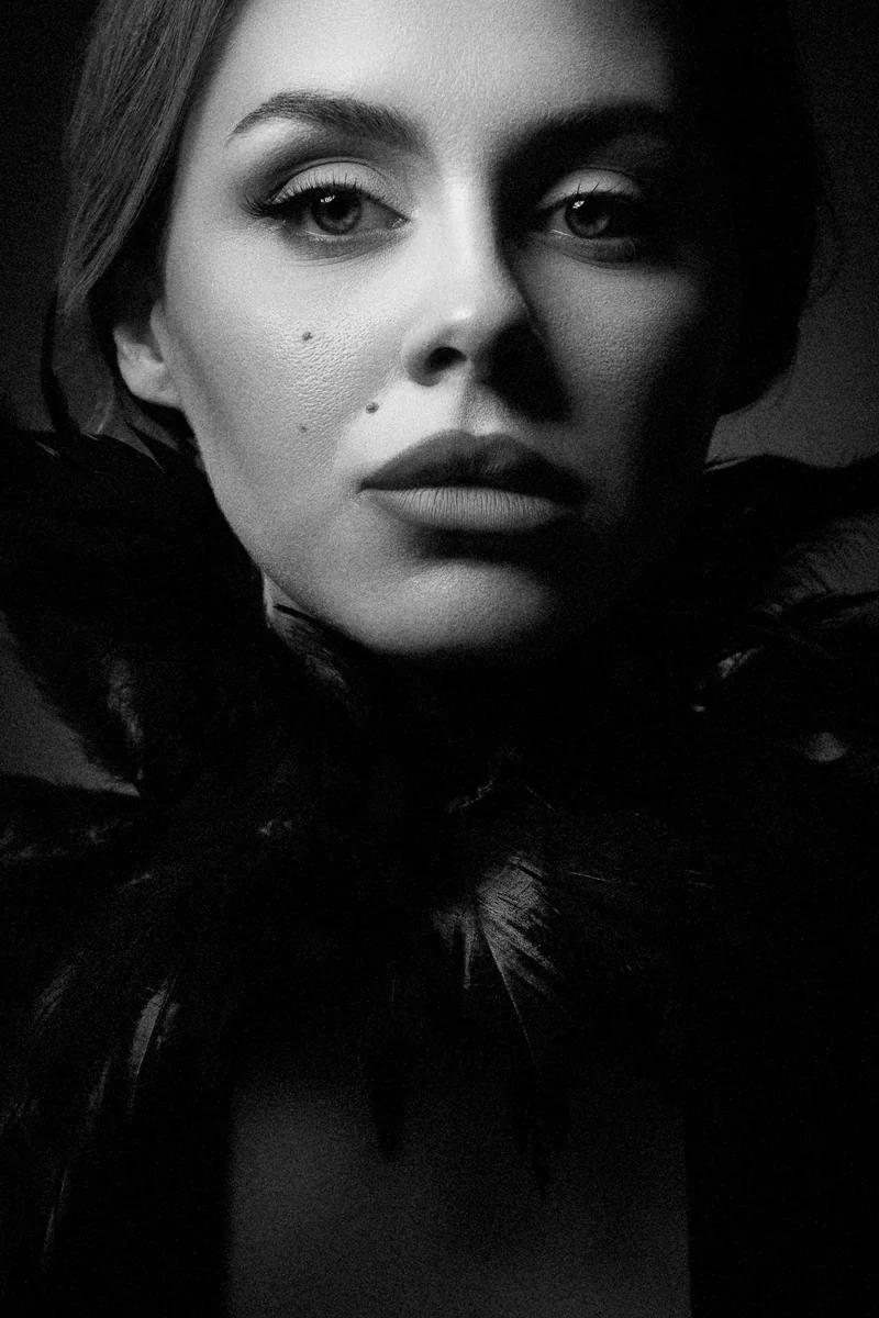Woman with a collar of black feathers in dramatic light