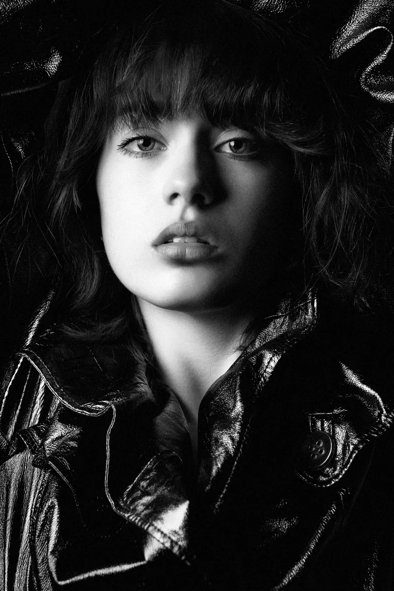Woman with a fringe and wavy hair in a black leather jacket