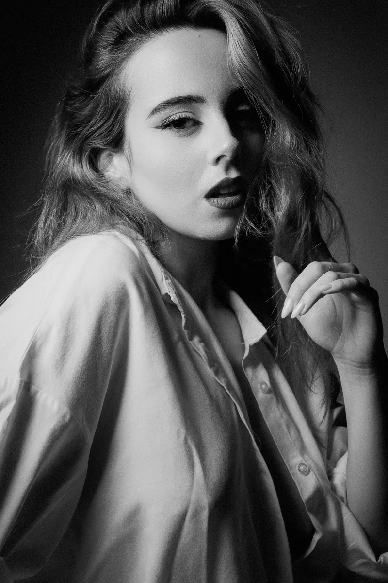 Blonde woman with wavy hair in an oversized white shirt