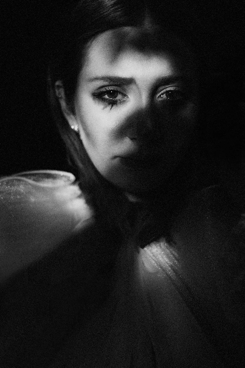 Woman with her face half in shadow and a tulle collar