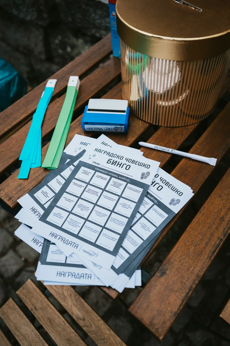 “Human bingo” game cards, wristbands and a stamp on a wooden table