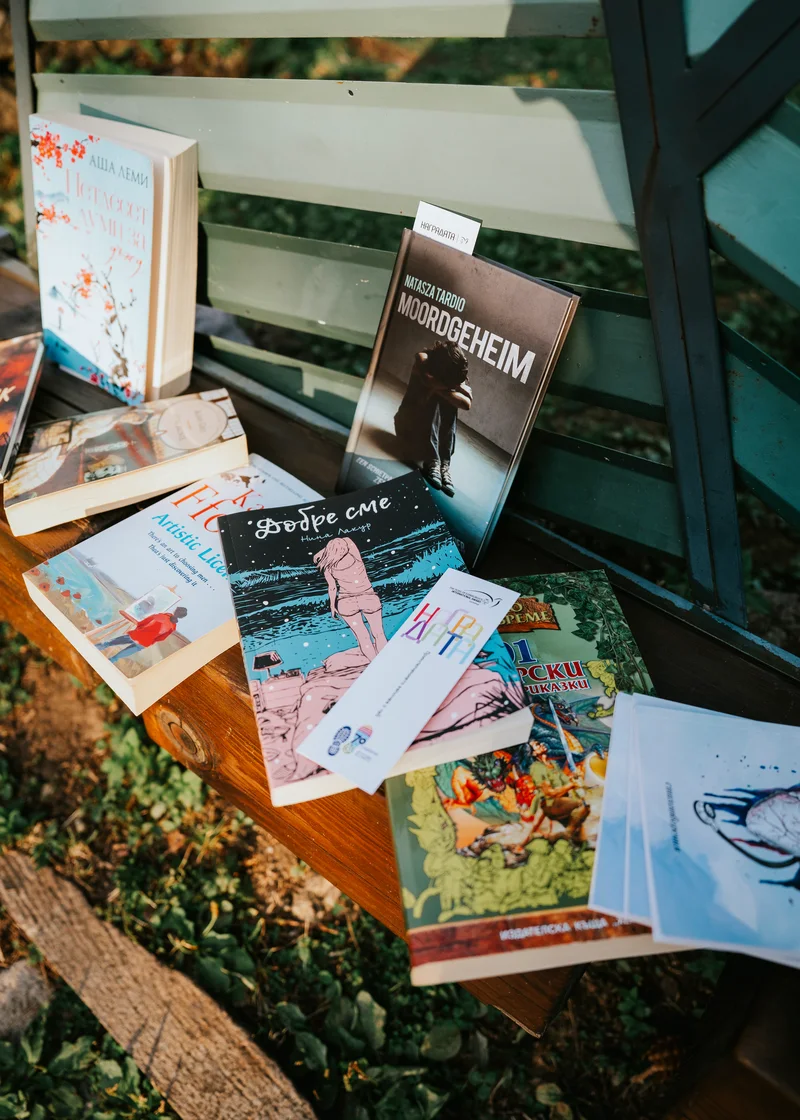 Books laid out on a wooden bench outdoors