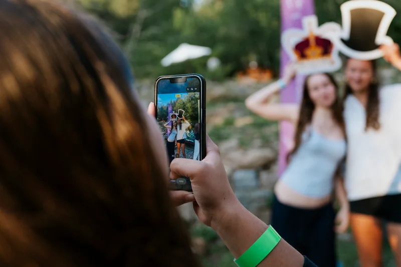A guest photographing the two women and their props with a phone