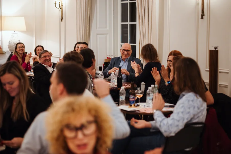 Guests at their tables laughing and applauding during the evening