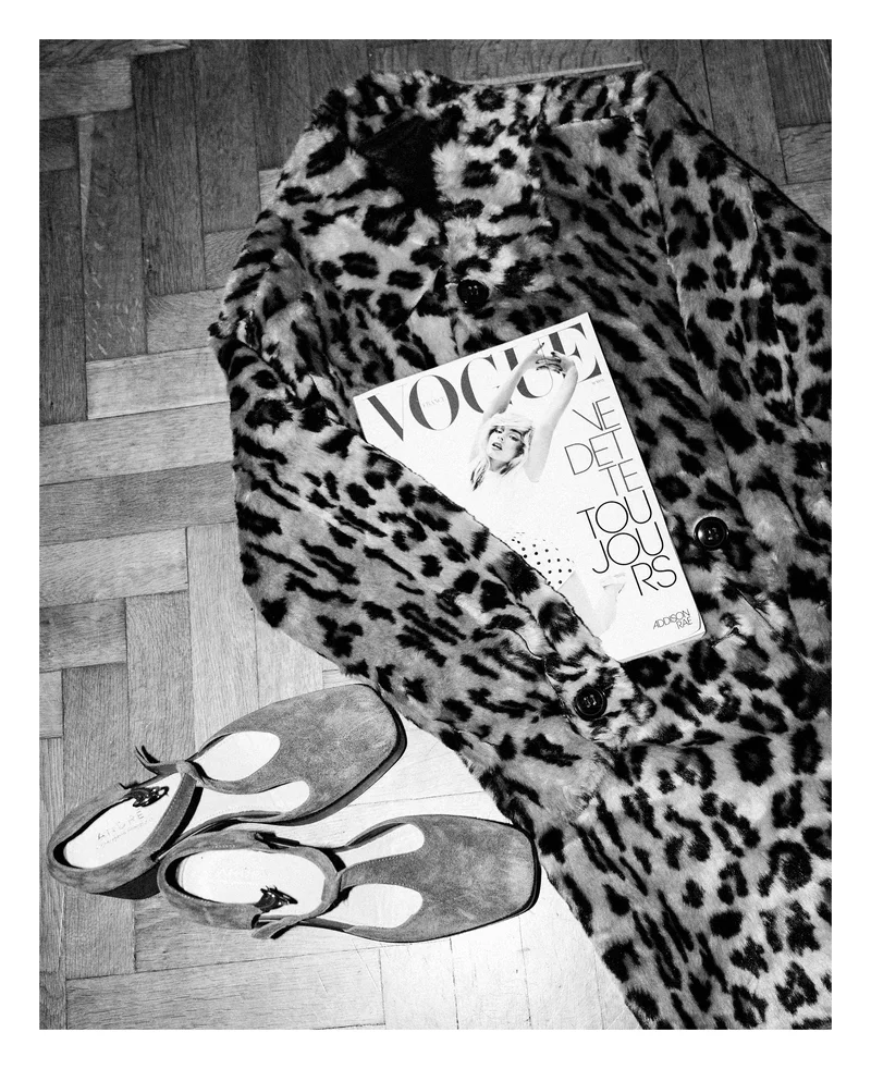 Leopard-print coat, a Vogue magazine and shoes on a parquet floor, in black and white