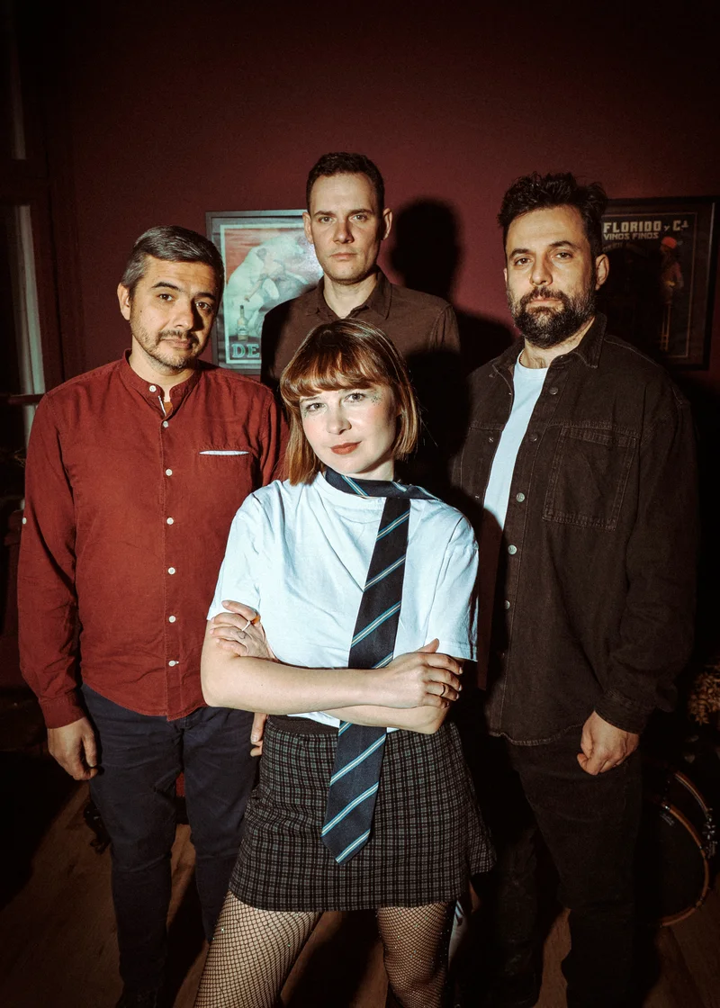 Band portrait with the woman in front, her arms crossed