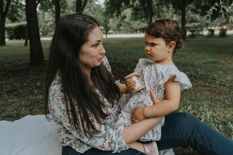 Woman and a small child on a blanket in the park