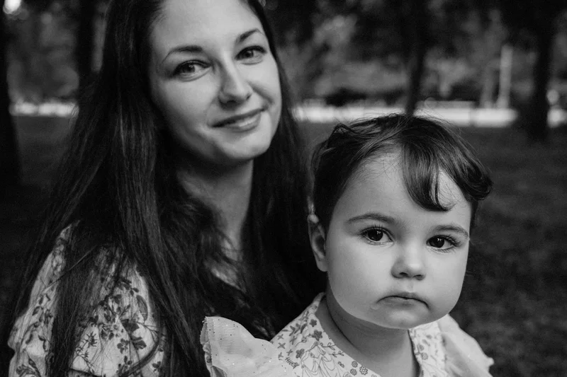 Smiling woman and a small child looking at the camera, in black and white