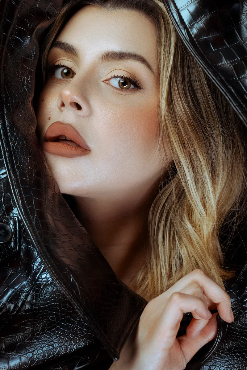 Blonde woman framed by the collar of a black leather coat
