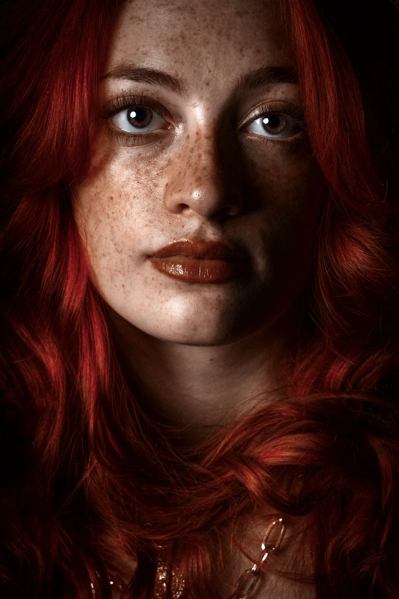 Close portrait of a freckled woman with wavy red hair