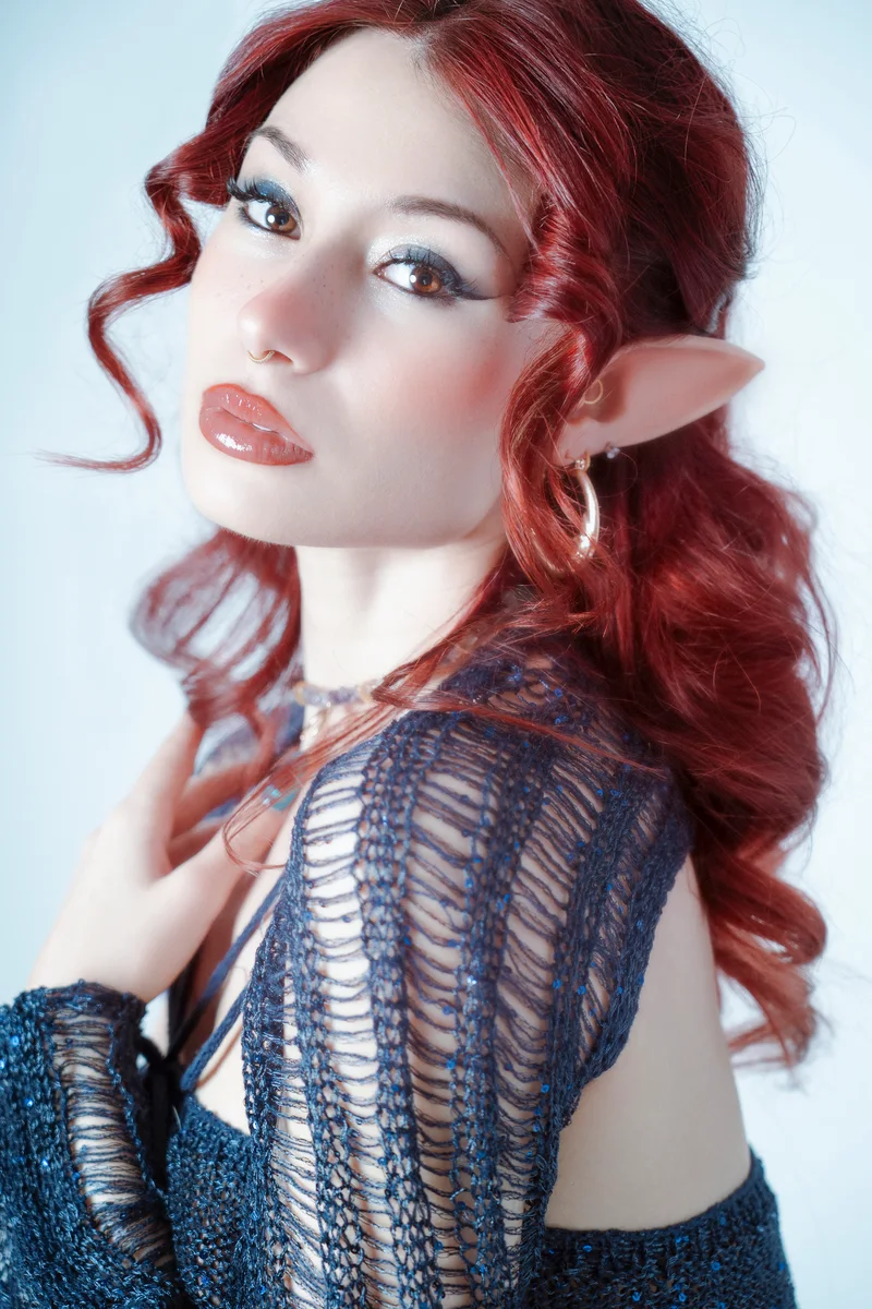 Red-haired woman with pointed elf ears in a blue lace dress